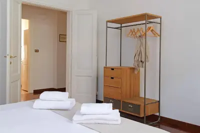 a bedroom with two white towels on a bed and a dresser at 4BNB - Vittorio Emanuele Apartment in Rome