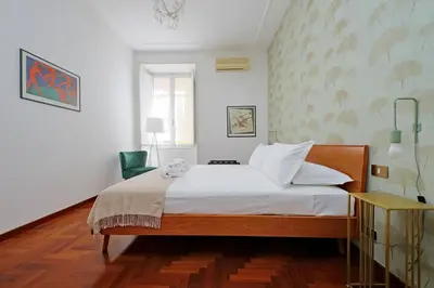 a bedroom with a bed with white sheets and a window at 4BNB - Vittorio Emanuele Apartment in Rome
