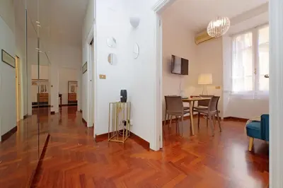 a living room with a wooden floor and a dining room at 4BNB - Vittorio Emanuele Apartment in Rome