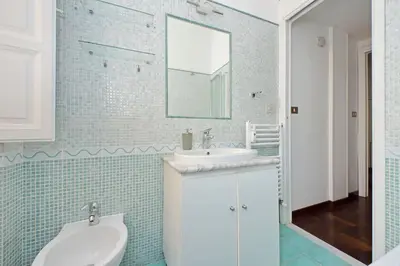 a bathroom with a white sink and a mirror at 4BNB - Vittorio Emanuele Apartment in Rome