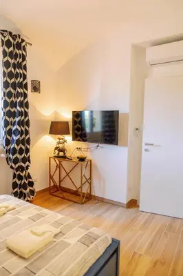 a bedroom with a bed and a tv on a wall at Roma Centro Holiday House in Rome