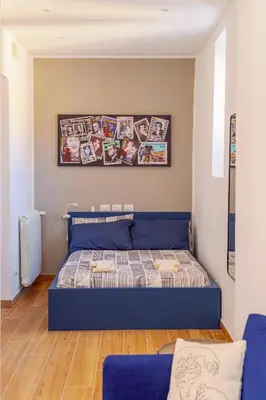 a bedroom with a blue bed in a room at Roma Centro Holiday House in Rome