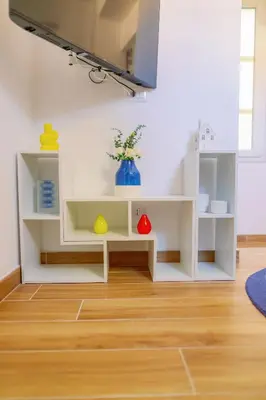 a living room with white shelves and a wooden floor at Roma Centro Holiday House in Rome