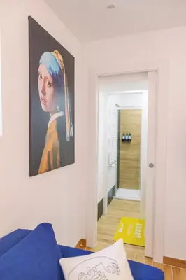 a painting of a woman on a wall in a living room at Roma Centro Holiday House in Rome