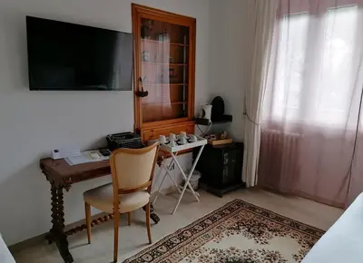 a room with a desk and a television and a chair at Gregory Place in Rome