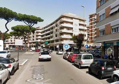 a busy city street with cars parked on the road at Gregory Place in Rome