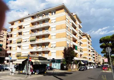 a large building on a city street with cars parked at Gregory Place in Rome