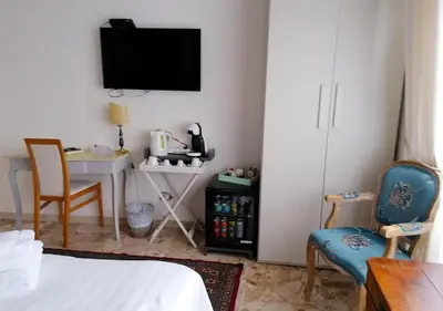 a bedroom with a bed and a desk and a tv at Gregory Place in Rome