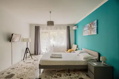 a blue bedroom with a bed and a window at AMA Roma 5 minuti dal Colosseo in Rome