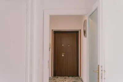 a hallway with a brown door and a mirror at AMA Roma 5 minuti dal Colosseo in Rome
