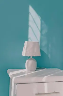 a white lamp sitting on top of a dresser at AMA Roma 5 minuti dal Colosseo in Rome