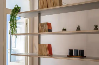 a row of shelves with books and plants on them at iFlat Discovering Monti - Charming and Modern apt in Rome