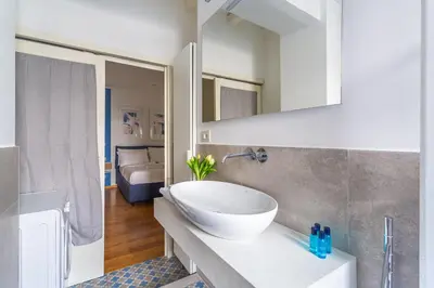 a bathroom with a white bowl sink on a counter at iFlat Discovering Monti - Charming and Modern apt in Rome