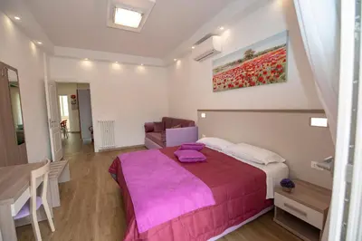 a bedroom with a large bed with a purple blanket at rainbow al colosseo in Rome