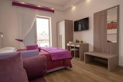 a bedroom with a purple bed and a table at rainbow al colosseo in Rome