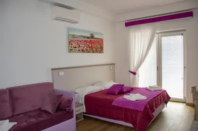 a bedroom with a purple bed and a couch at rainbow al colosseo in Rome