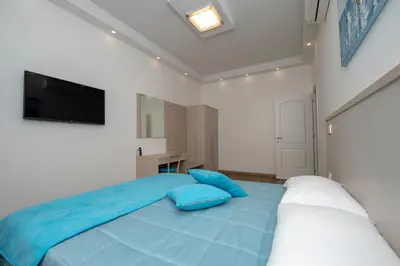 a bedroom with a blue bed and a flat screen tv at rainbow al colosseo in Rome