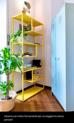 a yellow shelf in a room with a plant at Testaccio Artistic Home - Centro Storico Roma - RIONI DI ROMA in Rome