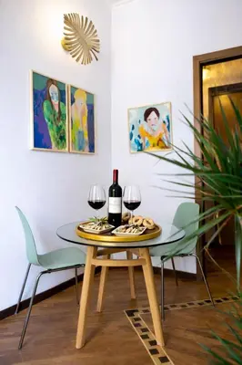 a dining room with a table and two glasses of wine at Testaccio Artistic Home - Centro Storico Roma - RIONI DI ROMA in Rome