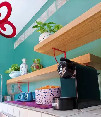 a kitchen with wooden shelves and a coffee maker on a counter at Testaccio Artistic Home - Centro Storico Roma - RIONI DI ROMA in Rome