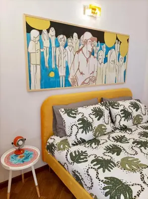 a bedroom with a bed with a painting on the wall at Testaccio Artistic Home - Centro Storico Roma - RIONI DI ROMA in Rome