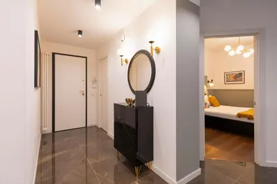 a hallway with a mirror and a bed in a room at Roomeasy Vatican Apartment in Rome