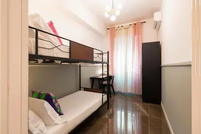 a bedroom with two bunk beds and a table at Roomeasy Vatican Apartment in Rome