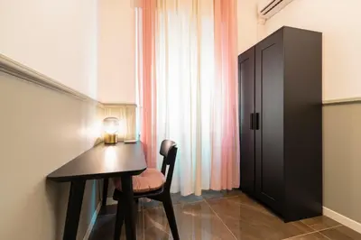 a room with a desk with a chair and a window at Roomeasy Vatican Apartment in Rome