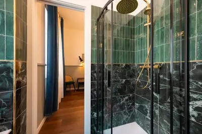 a bathroom with a shower with green tiles at Roomeasy Vatican Apartment in Rome
