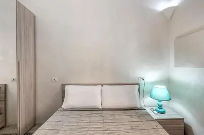 a bedroom with a bed with a blue lamp at Casa Mecenate in Rome