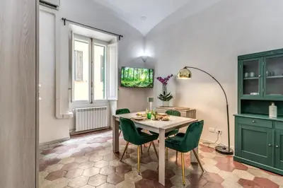 a dining room with a table and green cabinets at Casa Mecenate in Rome