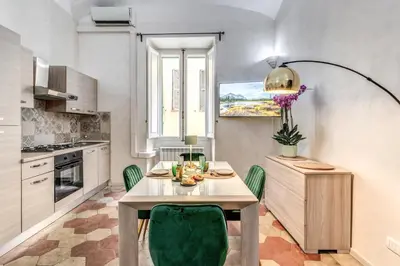a kitchen with a table and green chairs at Casa Mecenate in Rome