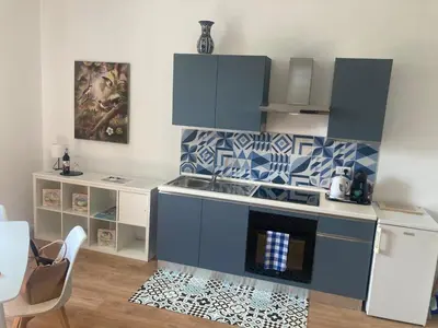 a kitchen with blue cabinets and a stove top oven at Domus Provinciae in Rome