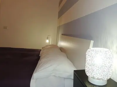 a bedroom with a bed with a white pillow and a lamp at Apt Central Magenta in Rome