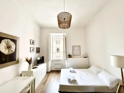 a white bedroom with a bed and a window at Camilla Charme in Rome