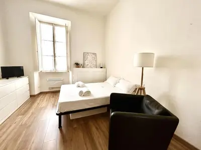a bedroom with a bed and a chair and a window at Camilla Charme in Rome