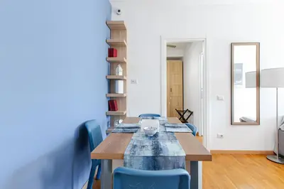 a dining room with a table and blue chairs at Metro San Paolo -Capitol Haus Roma- Cozy Apartment in Rome