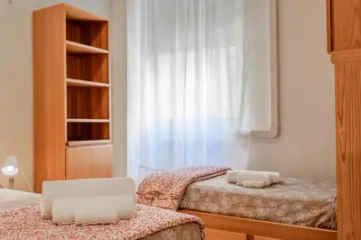 a bedroom with two twin beds and a window at Roma Monteverde Apartment in Rome