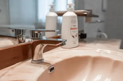 a sink with a faucet and two bottles of soap at Roma Monteverde Apartment in Rome