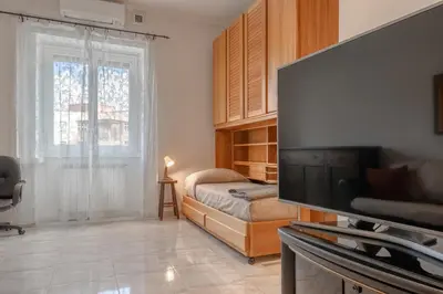 a living room with a television and a bed at Roma Monteverde Apartment in Rome