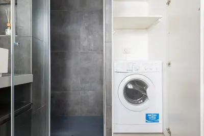 a washer and dryer in a small bathroom at Elegant Hideaway Steps from St Peter in Rome