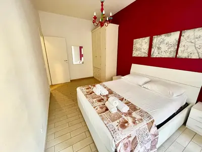 a bedroom with a large bed with red walls at Domus Laterani by JFM - Comfortable apartment big terrace Colosseo in Rome