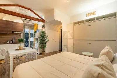 a bedroom with a white bed and a kitchen at Domus Romana Musei Vaticani in Rome