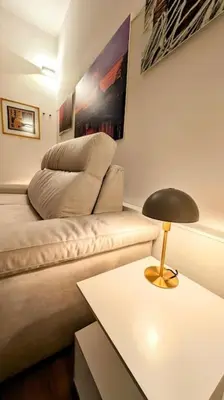 a living room with a couch and a table with a lamp at Cozy Home in San Cosimato in Rome