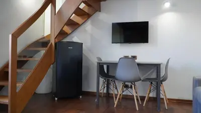a room with a desk and a television and a staircase at Al 25 Trastevere, Roma in Rome