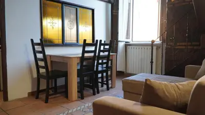 a table and chairs in a room with a window at Al 25 Trastevere, Roma in Rome