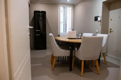 a dining room table with white chairs and a laptop at Maison Chic Spagna in Rome