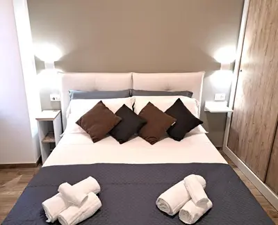 a bedroom with a large bed with two towels on it at San Giovanni Metro Flat in Rome