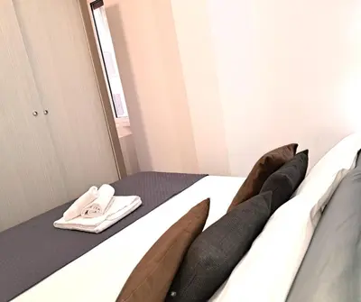 a bedroom with a bed with long black pillows at San Giovanni Metro Flat in Rome