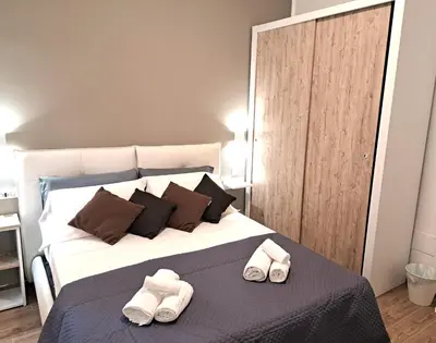 a bedroom with a bed with two slippers on it at San Giovanni Metro Flat in Rome